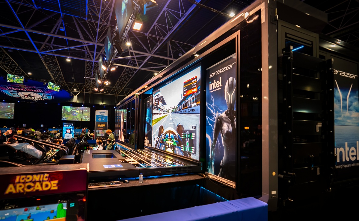 A gaming trailer at an expo, with vibrant displays showcasing racing games and product branding. Attendees engage with interactive gaming setups, while the versatile trailer design highlights the immersive experience.